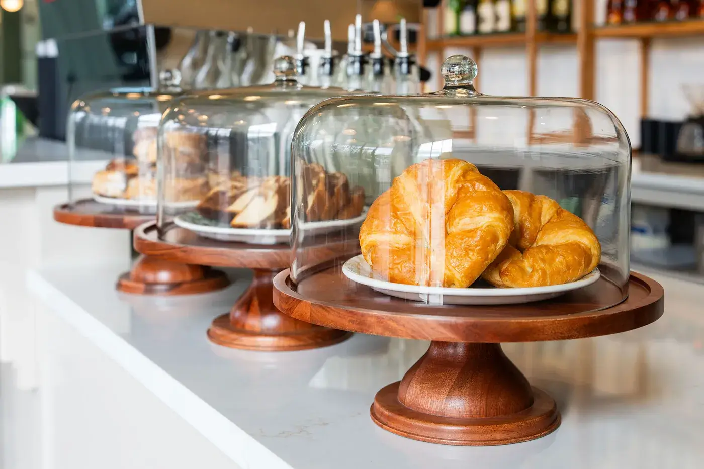 Croissants under glass display domes | DeGraaf Interiors